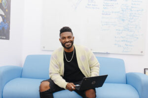 Smiling man on couch with laptop