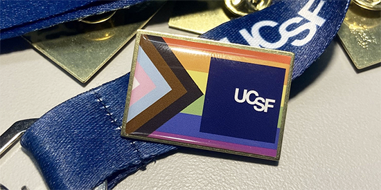 The UCSF Pride progress pin on a lanyard