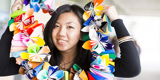 Woman holding colorful paper flower lei