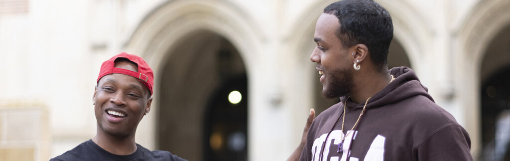 Two young people smiling together outside UCLA building