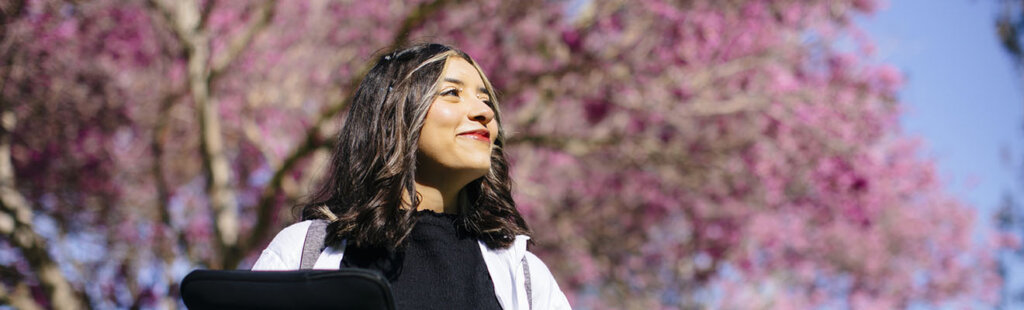 Person smiling under cherry blossoms