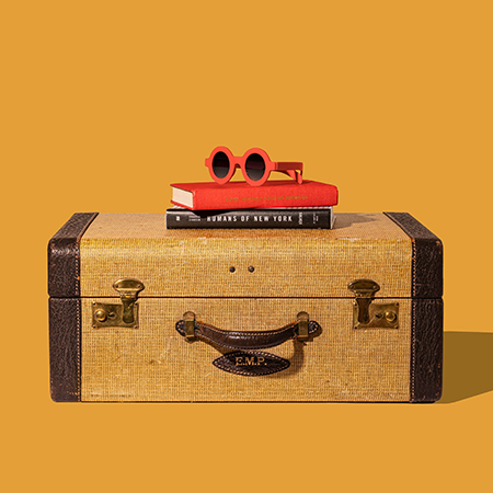 Vintage suitcase, books and sunglasses