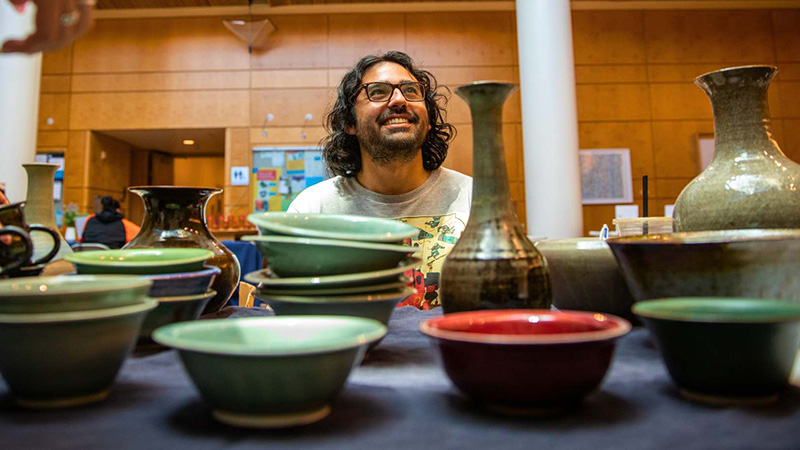 Asa Kalish with their handmade ceramic pieces.