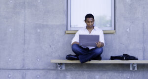 man with a laptop on a bench