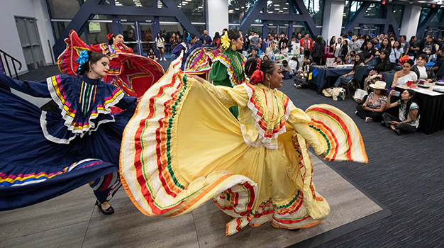 Women dancing in traditional Mexican dresses