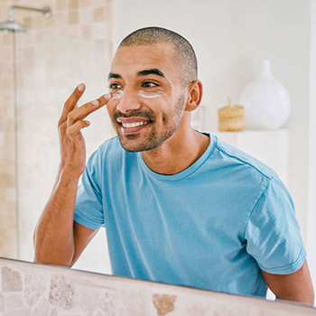 Man applying sunscreen in a mirror