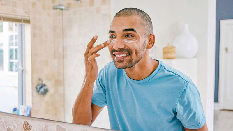 Man applying sunscreen in a mirror