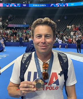 Matt Ustaszewski holding his Olympic medal.