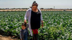 Maria Ventura and her son, Karim, walk through a field