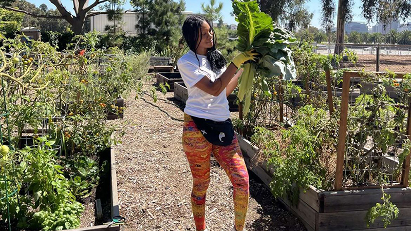 Veteran Cyntrea Cotton holding a plant in the garden