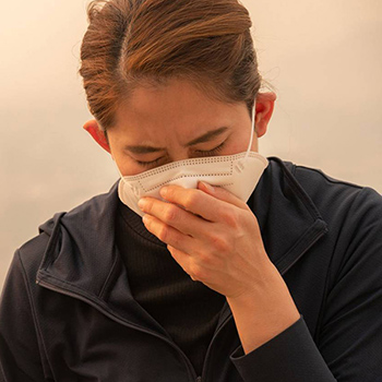 Woman covering her face with an N95 mask during a wildfire