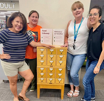 Women posing with seed library