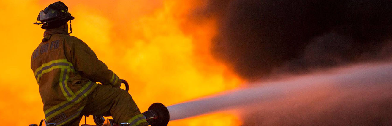 Firefighter aiming water at blaze