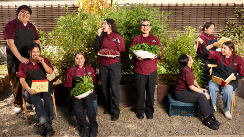 Students and staff holding produce