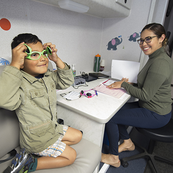 A health care worker prepares a child for glasses