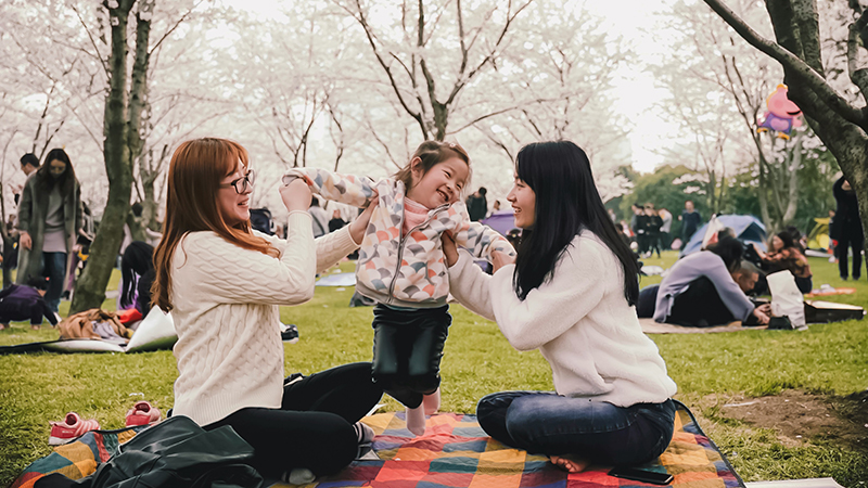 women with young girl in park