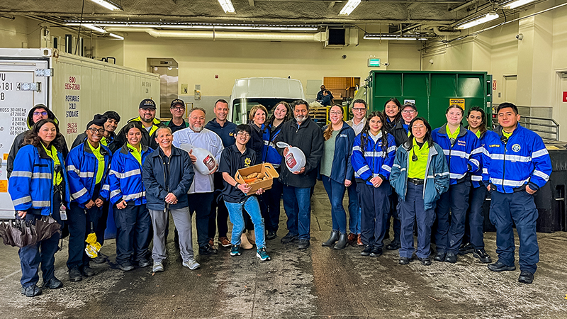 Group of students and officers pose with a turkey