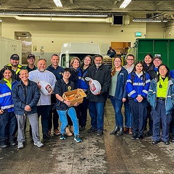 Group of students and officers pose with a turkey