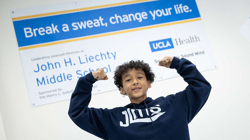 Eighth grader Gilbert Martinez is excited to try out a rowing machine at his school's new fitness center. (Photo by Nick Carranza)