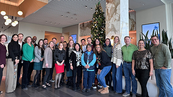 Group of people standing around a holiday tree