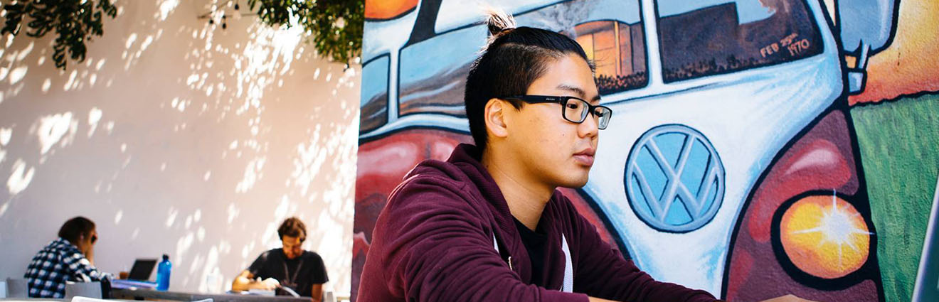 Students on UCSB campus outside in front of colorful mural