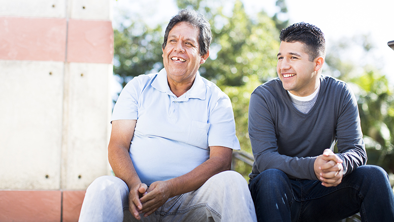 Older and younger man conversing