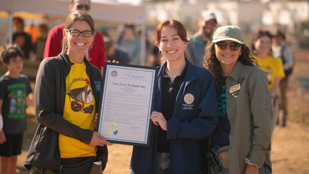 Kellie Uyeda, executive director of the UC San Diego Natural Reserve System (left) and Cristina Santa Maria, conservation manager at the San Diego Bird Alliance (right), accept Love Your Wetlands Day proclamation from Cambria Head, Community Representative for Council President Joe LaCava, City of San Diego. Photo by Erik Jepsen/UC San Diego