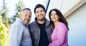 Three people of different ages standing together