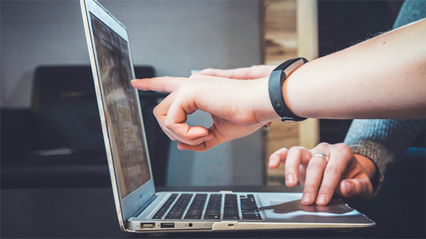 People pointing at a laptop screen