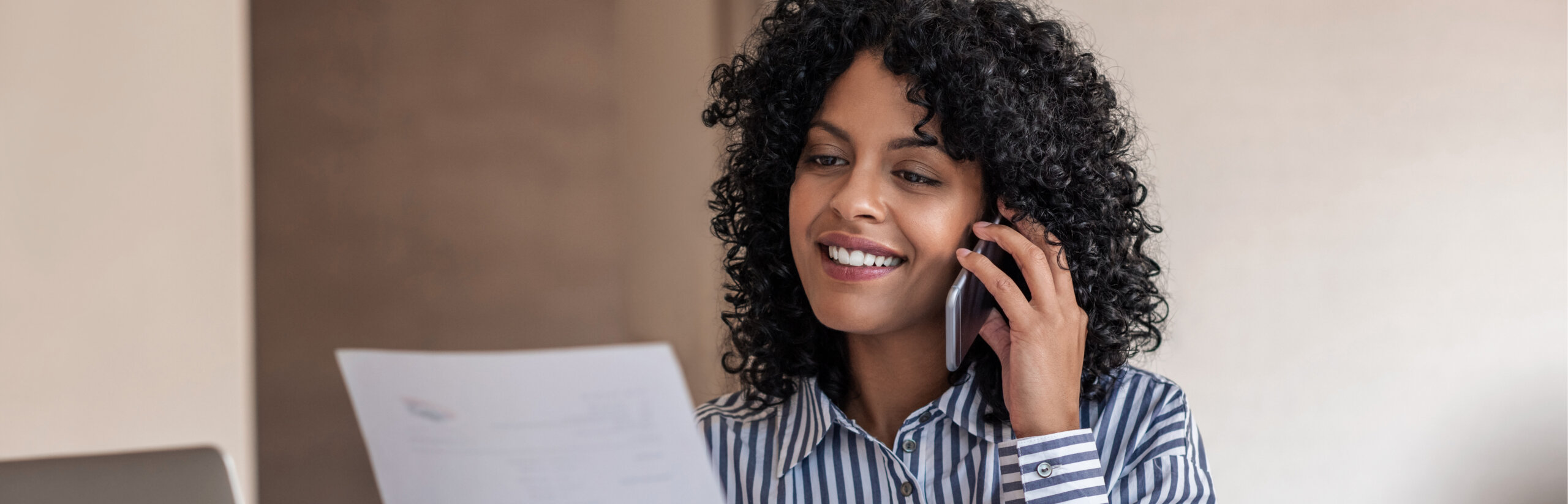 Woman talking on the phone about a paper she's holding