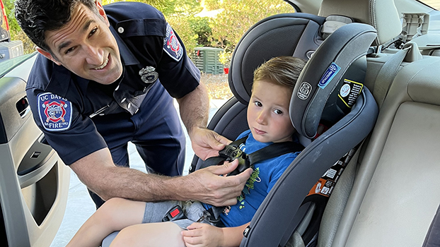 Fire Engineer Ben Rizzo demonstrates a car seat installation