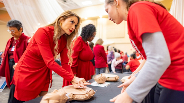 A woman practices hands-only CPR