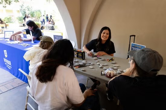 Students painting rocks at a table