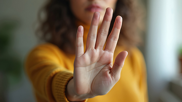 Close-up young woman palm hand making stop gesture.