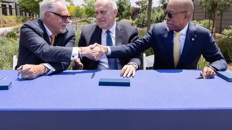 Chancellors and PMVD signing an agreement outside at a table