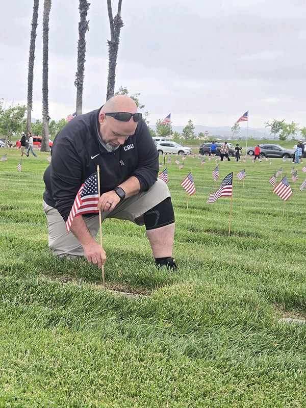 Man placing flag on grave