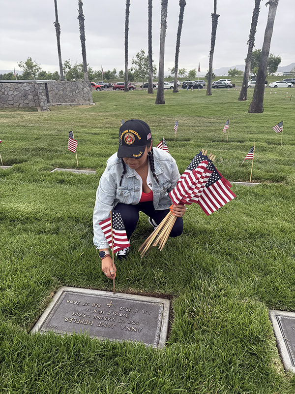 Woman placing flag on grave