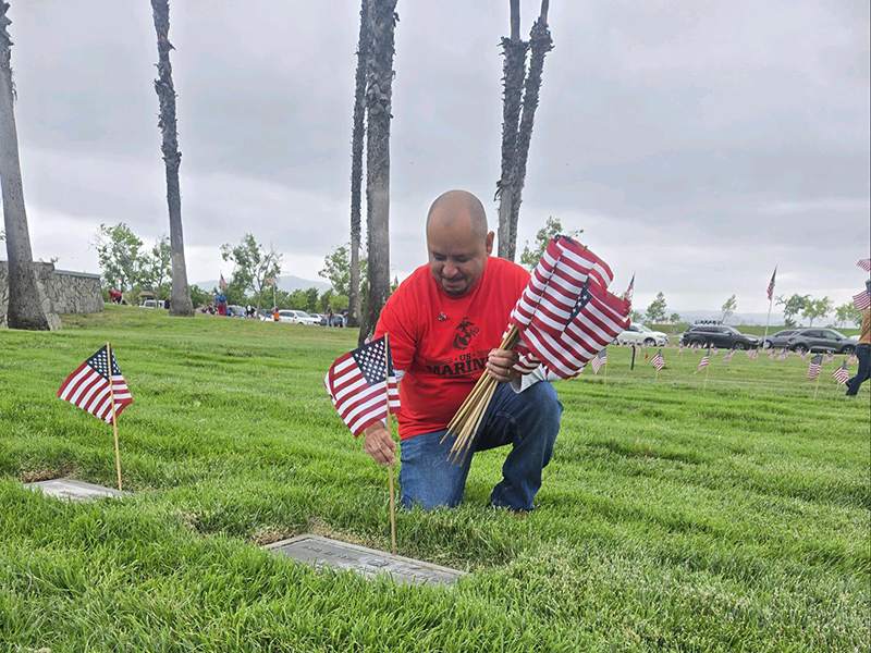 Man placing flag on grave