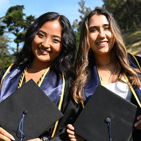 Two young women in graduation garb