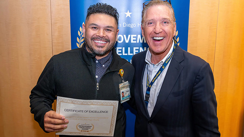 Group of smiling people holding a certificate
