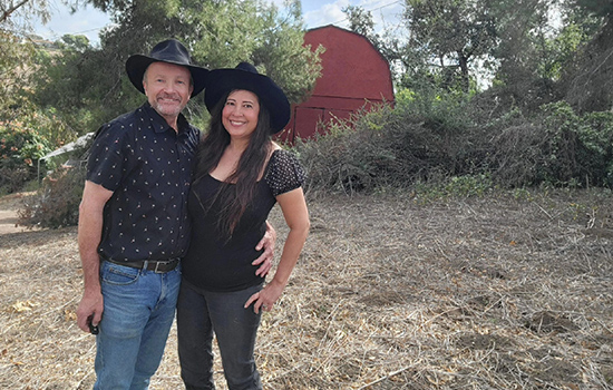 Man and woman standing in front of a barn