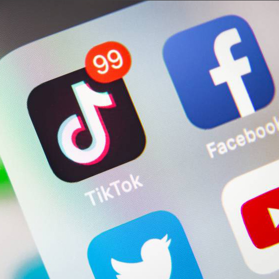 Social media icons on a phone with 99 TikTok notifications
