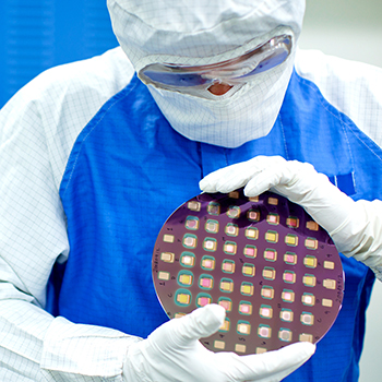Person wearing protective gear holding a scientific device