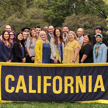 Group of people holding a large banner with the word “California.”