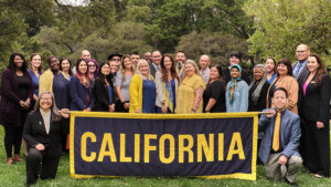 Group of people holding a large banner with the word “California.”