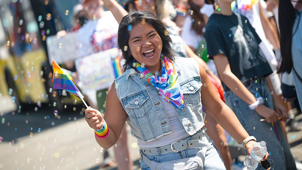 Woman waving a tiny Pride flag