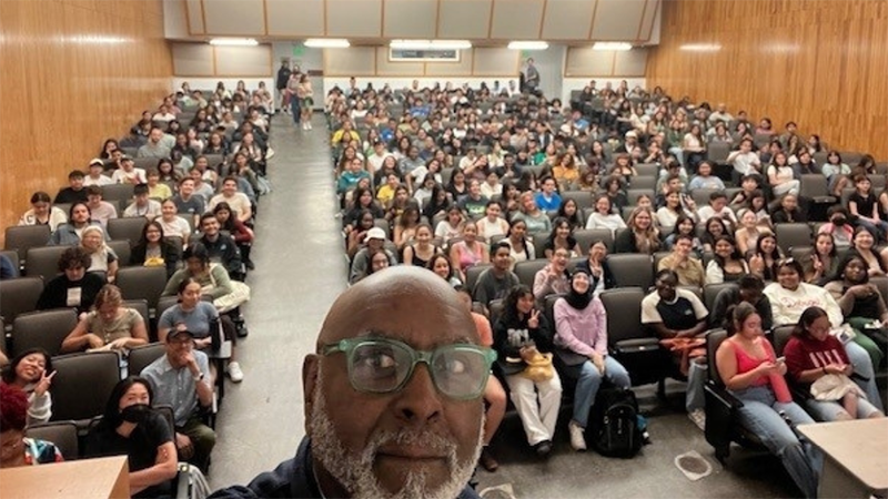 Charles taking a selfie with room of students