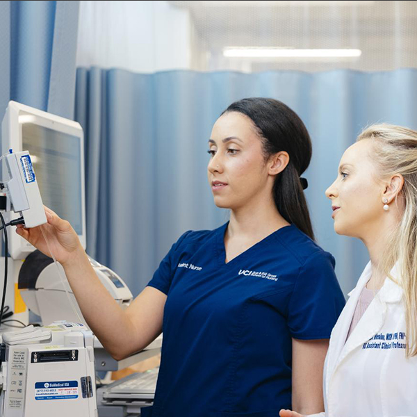 A doctor and nurse consult a monitoring panel