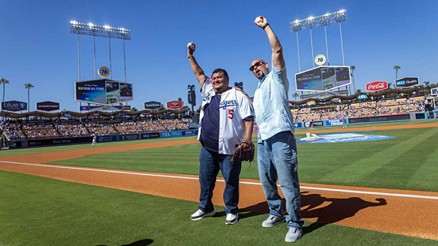Jose Morales, left, and Jose Avina celebrate Morales’ success at Dodger Stadium on a day on which members of the Homeless Healthcare Collaborative were honored.
