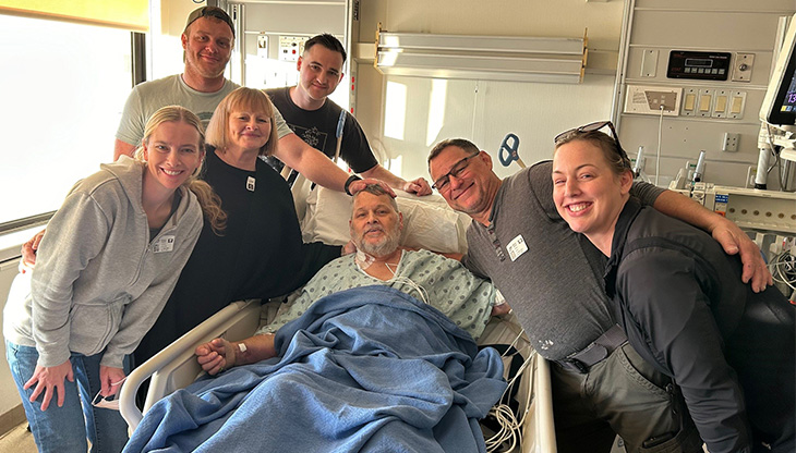 Family around man in hospital bed
